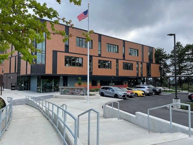 A two story brick building has a walkway leading toward it